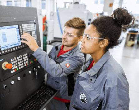Zwei Lehrlinge arbeiten an einer Maschine im RIC